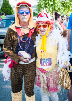 Two adults dressed in chicken costumes.